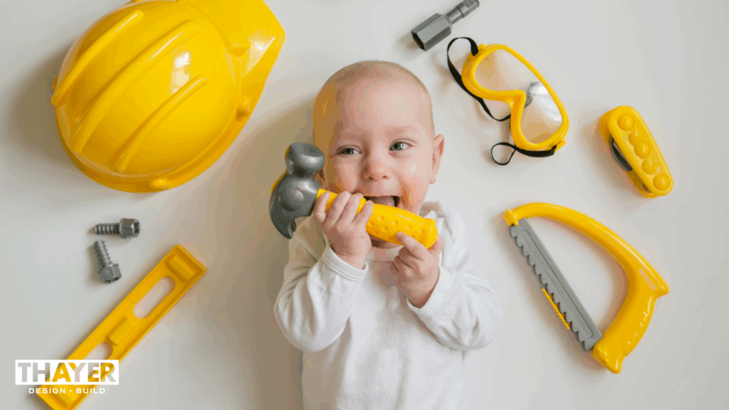 Baby holding toy hammer at a home remodel